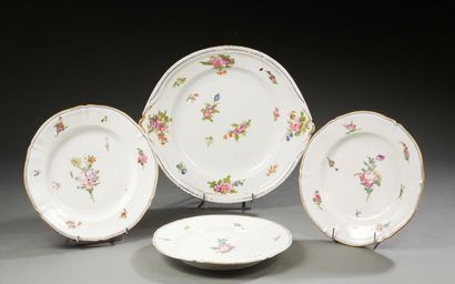 PARIS Trois assiettes à bords contournés et un plat rond en porcelaine à deux anses...