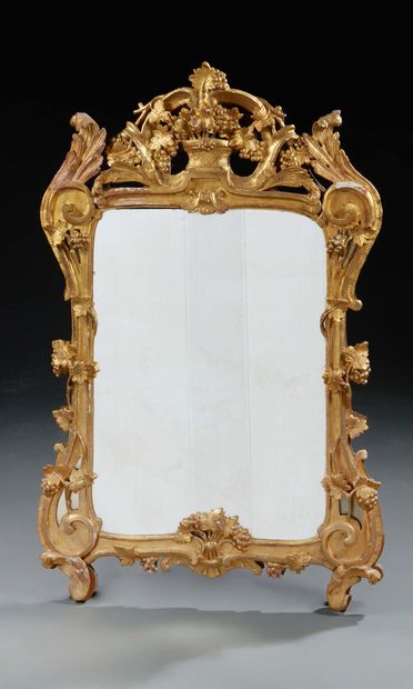 null Carved and gilded wood MIRROR. The pediment is decorated with a vase and vines.
Early...