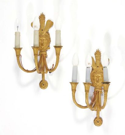 null A Pair of three-light sconces in finely chased and gilded bronze; the plates...