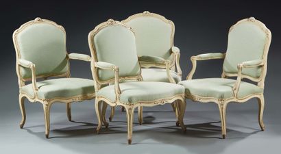 null SUITE OF FOUR FLAT-BACKED ARMCHAIRS in moulded, carved and cream lacquered wood...