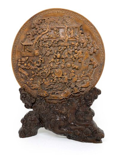 CHINE Circular plate in carved exotic wood representing the hundred children treated...