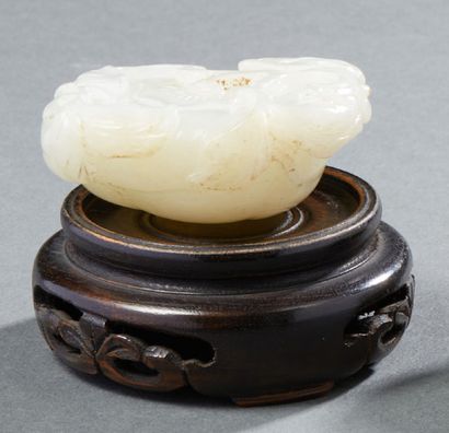 CHINE Rare and beautiful carved light jade representing a water lily bud framed by...