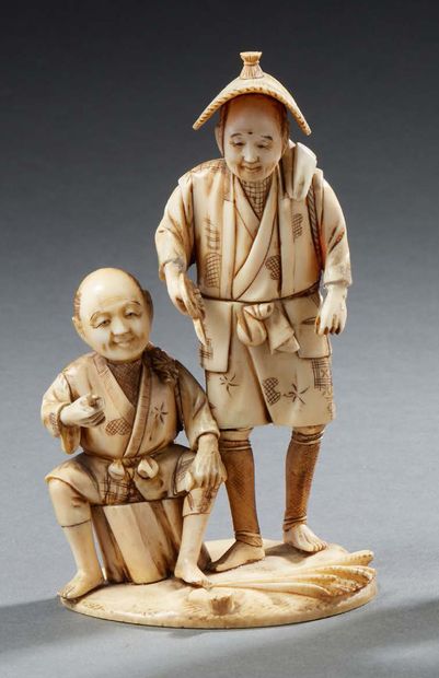 JAPON °°° Okimono en ivoire sculpté représentant deux paysans, l'un d'entre eux assis...