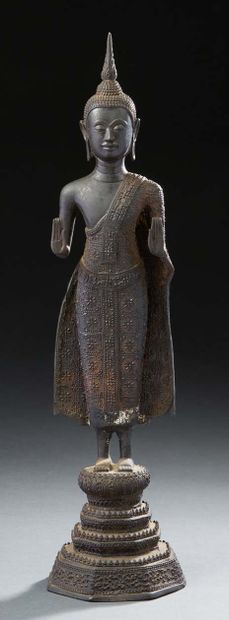 THAÏLANDE Bronze figurine with brown patina representing a Buddha standing on a quadruple...