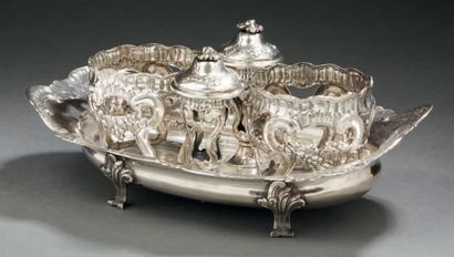 null A silver OIL AND WINE BASIN, standing on four feet with scrolls and leafy attachments....