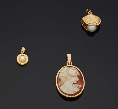 null LOT of three small PENDANTS in gold 750 mm, of which a circular one decorated...