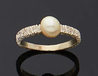 null Gold ring 750 mm decorated with a cultured pearl mounted on a textured body....