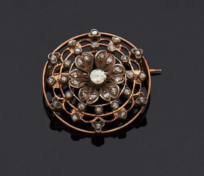  Circular brooch with a flower in its center set with a small diamond with multiple...