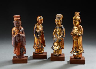 VIETNAM Ensemble de quatre statuettes en bois laqué et doré figurant des dignitaires....