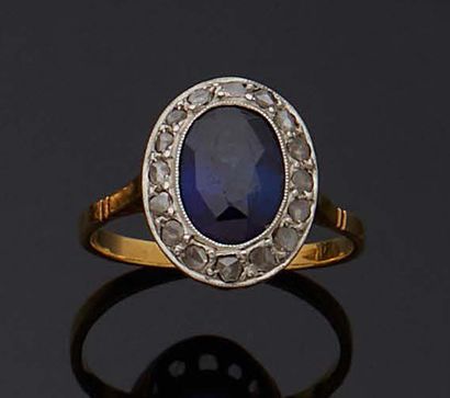 null BAGUE en or jaune 750 mm et platine, dite marguerite, ornée d'une pierre bleue...