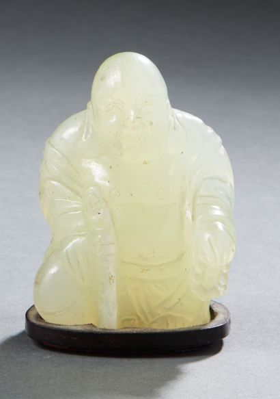 null Figurine en jade clair sculpté représentant un bouddha assis tenant un bâton...