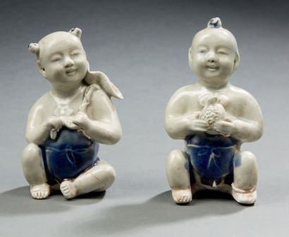 CHINE Deux figurines en porcelaine représentant les jumeaux hoho assis XXe siècle
H....