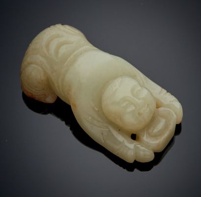 CHINE Figurine en jade clair sculpté avec traces de rouille représentant un enfant...