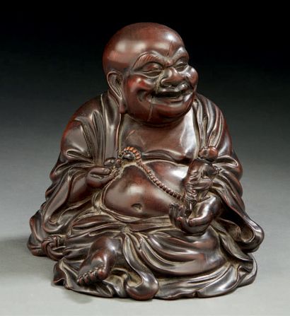 CHINE Carved wooden figurine representing a seated Buddha holding in his hand a miniature...