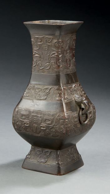CHINE Vase d'autel de forme cornet en bronze à patine brune décoré en léger relief...