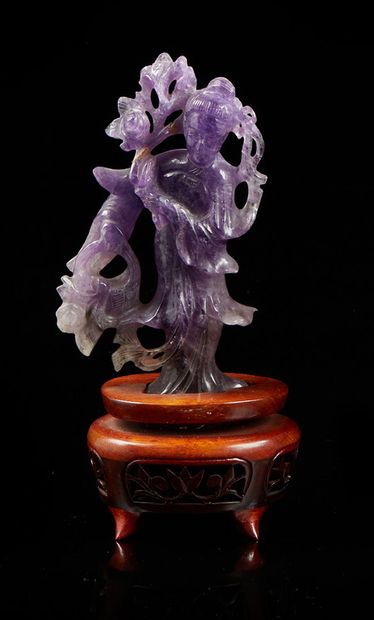 CHINE Carved amethyst figurine representing a Guanyin. Wooden base carved 
XXth century...