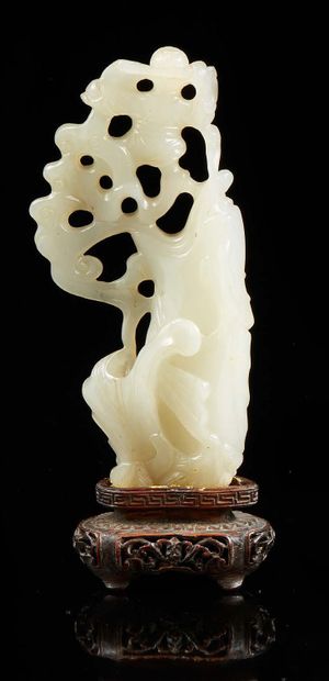 CHINE Groupe en jade clair sculpté et ajouré figurant un enfant encadré de vaguelettes,...