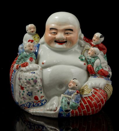 CHINE, XXe siècle Bouddhai en porcelaine re­présenté assis entouré de cinq enfants...
