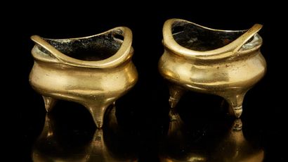 CHINE, XXe siècle Paire de petits brûle-parfum tripodes en bronze de patine dorée,...