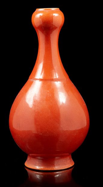 CHINE, XXe siècle Vase bouteille à long col en porce­laine émaillée monochrome corail.
H....