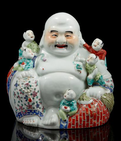 CHINE, XXe siècle Bouddhai assis souriant en por­celaine polychrome tenant le rosaire...
