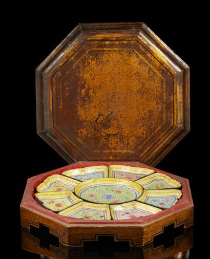 CHINE, XIXe siècle Boîte octogonale en bois laqué brun or, ouvrant sur neuf raviers...