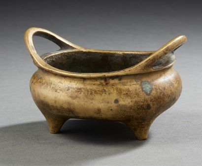 CHINE, XIXe siècle Petit brûle parfum tripode en bronze de patine doré à anses évasées.
D....