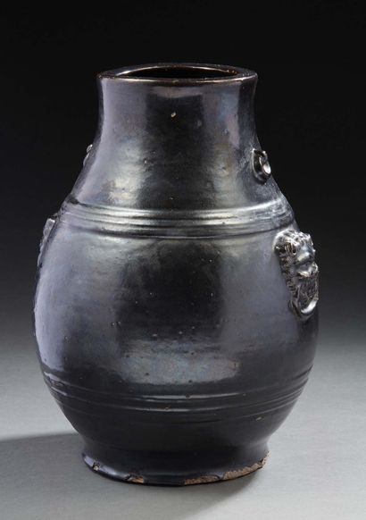 CHINE, XXe siècle Vase en terre cuite émaillée noire miroir.
Deux têtes de mascarons...
