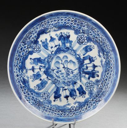 CHINE, XIXe siècle Assiette en porcelaine bleu blanc à décor rayonnant de personnages.
D....