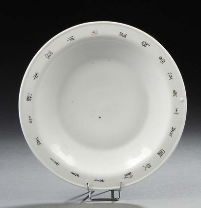 CHINE, XXe siècle Assiette en porcelaine blanche à motif de calligraphie sur l'aile.
Diam....