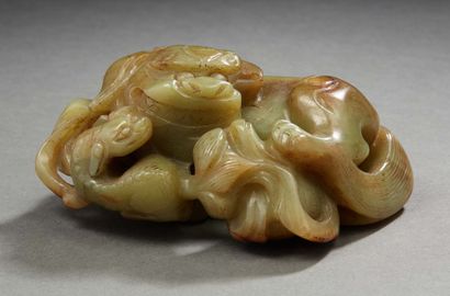 CHINE, XXe siècle Groupe sculpté dans un galet de jade jaune représentant un lion...
