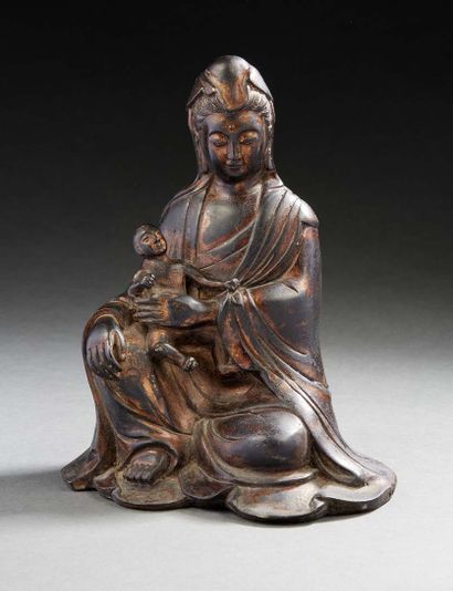 CHINE, XXe siècle Statuette en bronze figurant la déesse
Guanyin tenant un enfant.
H....