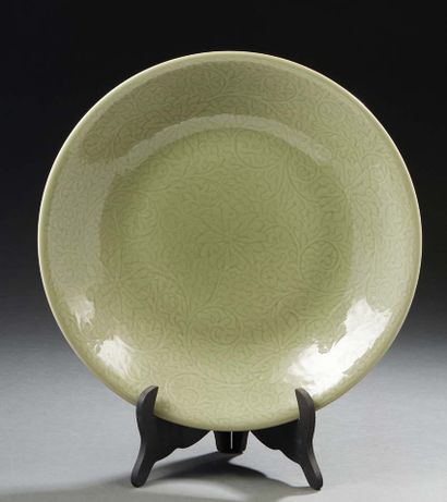 CHINE, XXe siècle Important plat en porcelaine émaillée céladon à décor sous couverte...