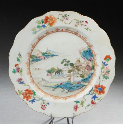 CHINE, XVIIIe siècle Assiette en porcelaine à décor d'un paysage et de motifs floraux...
