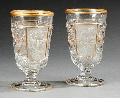 null DEUX VERRES en cristal taillé, flanqués par deux mascarons, liseret doré sur...