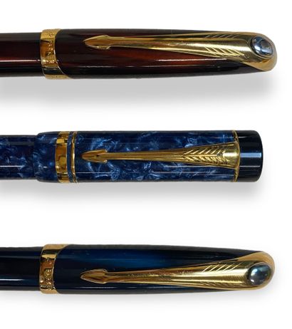 null PARKER 
ensemble de trois stylos plumes laqués et métal doré. 
Deux bleus métalisés...