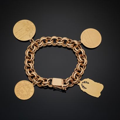 null BRACELET in yellow gold 585 mm with a curb chain holding four charms, three...