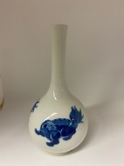 null CHINE
Vase à long col en porcelaine à décor bleu de chiens de fô. 
Marque au...