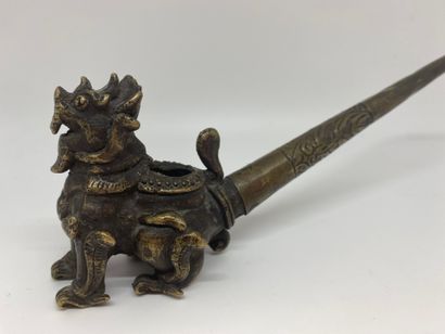 null CHINE
Une pipe à opium en bronze, la prise figurant un kilin.
L. : 23,5 cm.