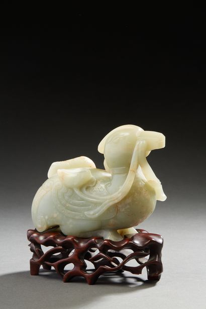 Chine, vers 1920 Groupe en jade céladon veiné de rouille représentant un canard tenant...