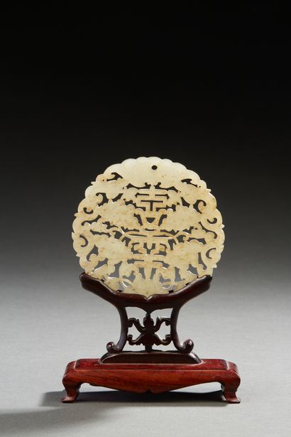 Chine vers 1900 Pendentif en jade céladon de forme circulaire sculpté d'une chauvesouris...