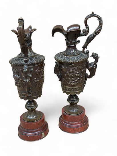null -Pair of small simulated ewers in chased and patinated bronze; the sides decorated...