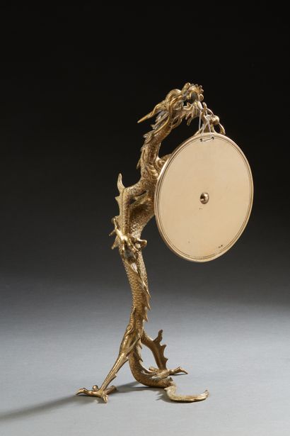 null Indochine, vers 1920, 
Dragon en bronze de patine doré, formant porte gong représenté...