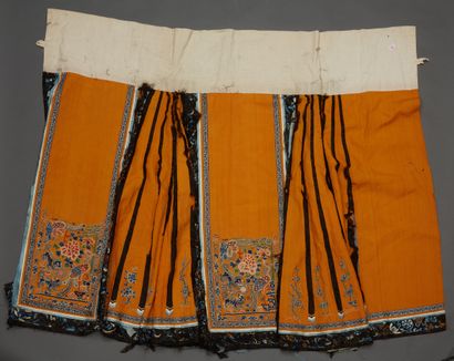 null Chine, XIXe siècle
Jupe en soie et lin brodé, à décor polychrome sur fond orangé...