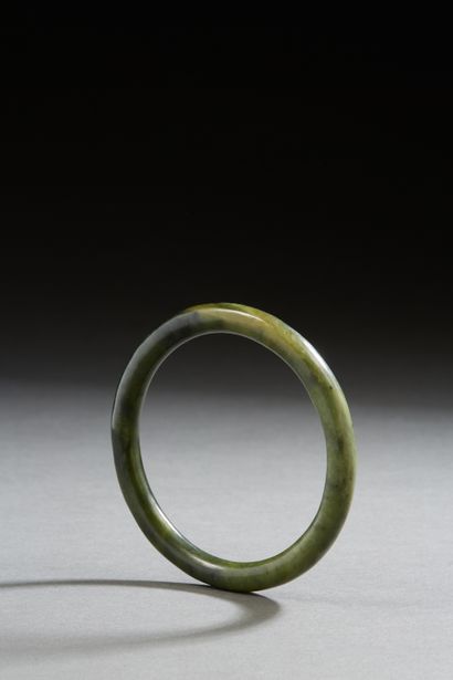 null Chine, XXe siècle
Bracelet jonc en serpentine vert épinard. 
Diam. 8,2 cm