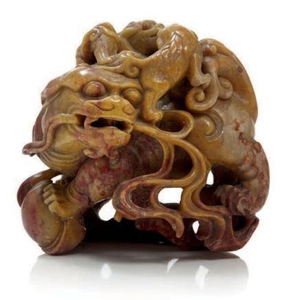 CHINE Groupe en steatite sculptée représentant un chien de fô tenant une boule, deux...