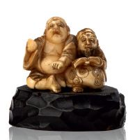 *JAPON 
Netsuké en ivoire sculpté représentant deux personnages assis, l'un lisant....