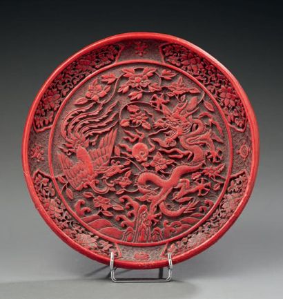 CHINE Plateau circulaire en bois laqué rouge, décoré d'un dragon pentadactyle et...