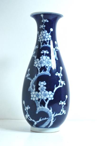 null Vase en porcelaine sur fond bleu à décor de fleurs. _x000D_

Marque au revers....