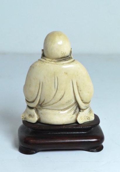 null Bouddha en ivoire sur socle en bois. 
H. : 10,5 cm.